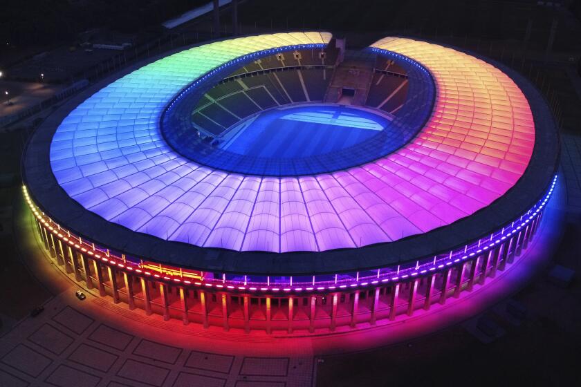 The rainbow-illuminated Olympic Stadium is pictured in Berlin, Germany, Wednesday, June 23, 2021. Scars of World War II and relics from its Nazi past are preserved at Berlin's Olympiastadion. When Spain plays England in the European Championship final, they will be playing in a stadium that doesn't hide it was built by the Nazis for the 1936 Olympic Games. (AP Photo/Michael Sohn)