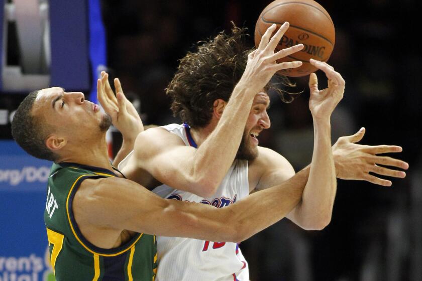 Clippers forward Spencer Hawes battles Jazz center Rudy Gobert in the second half Monday as Hawes returned to action after a nine-game absence.