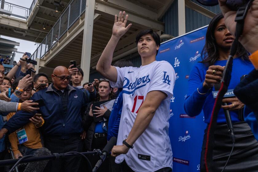 Dodgers star Shohei Ohtani waves to fans at the team's fanfest on Feb. 3, 2024, at Dodger Stadium.