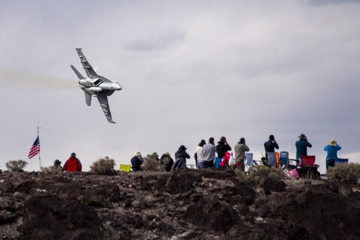 Photographers train their cameras at a fighter jet F-18, from Lemoore Naval Air Station, diving into Rainbow Canyon. 