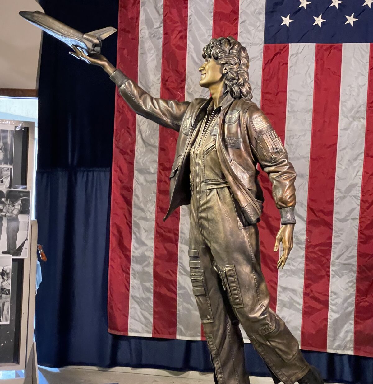 The Sally Ride statue with an American flag in the background