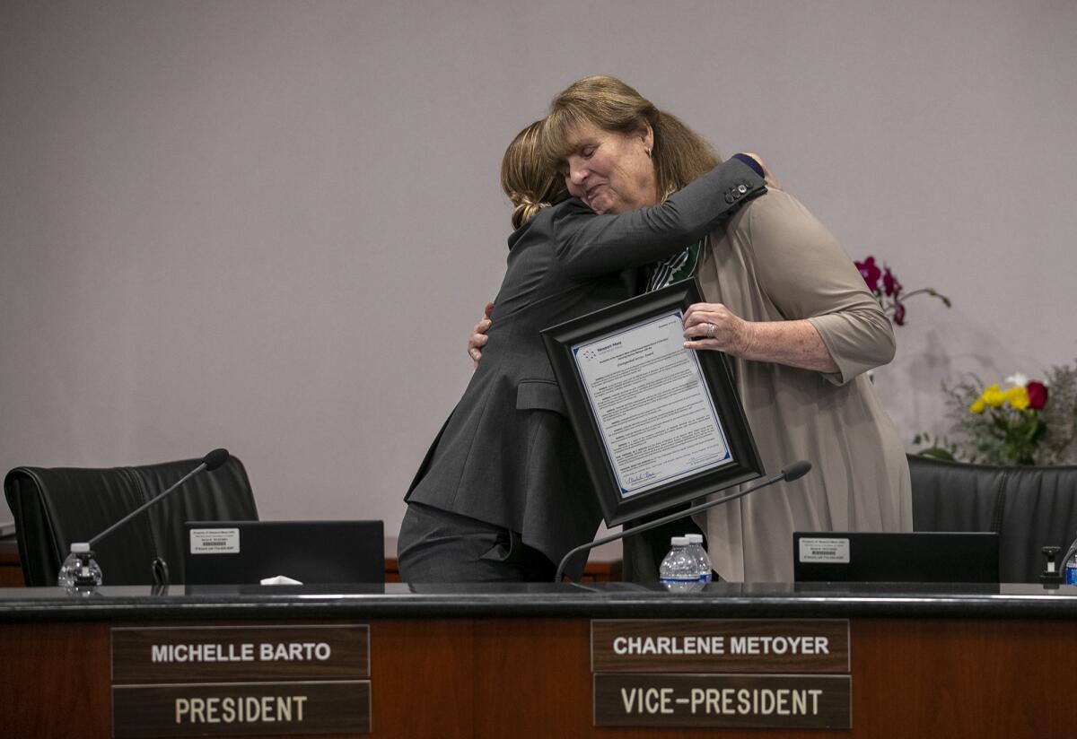 NMUSD president Michelle Barto hugs Charlene Metoyer Tuesday after presenting her with a Distinguished Service Award.