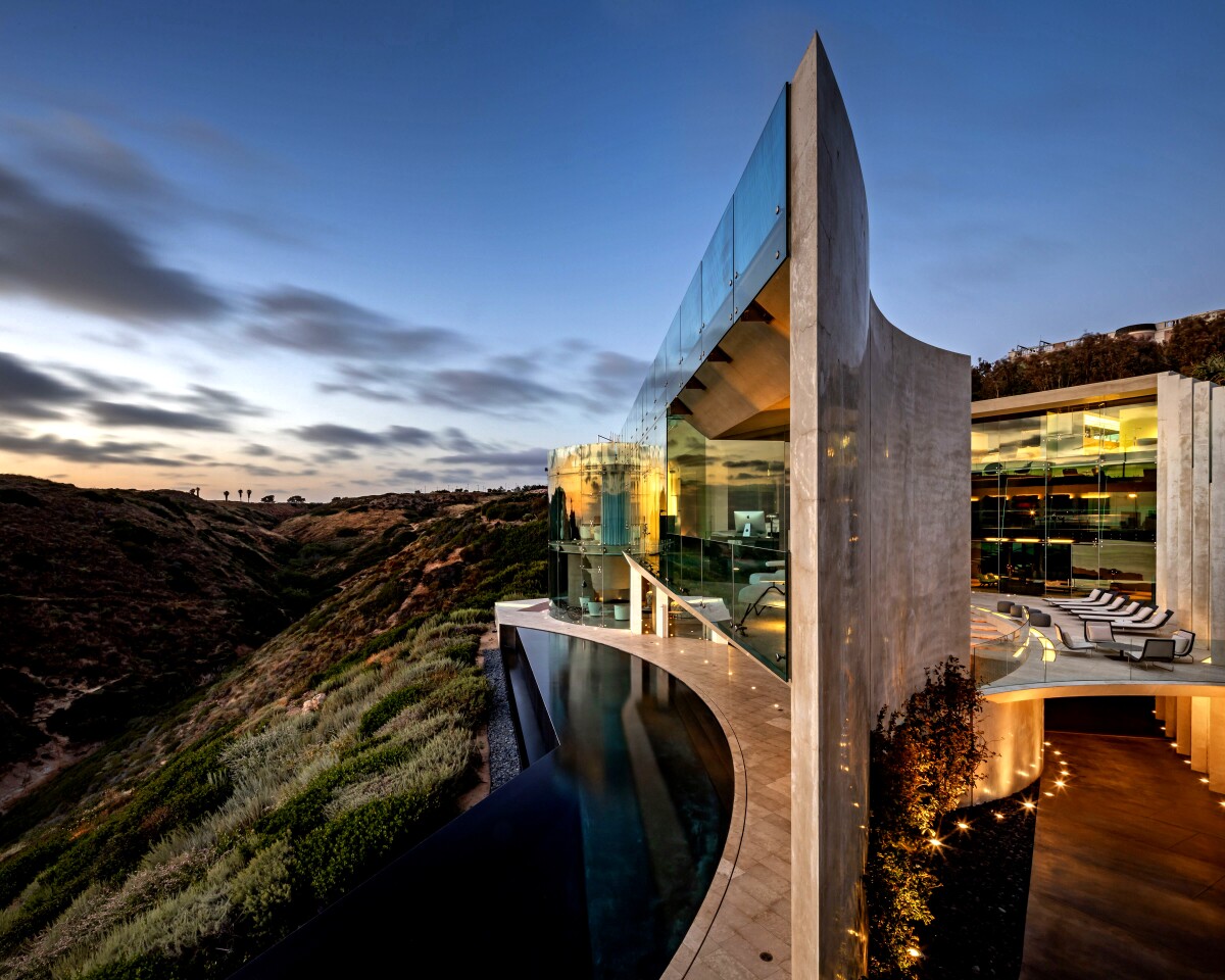 A cutting-edge blend of concrete and glass, the jagged, sweeping structure hugs the side of a cliff and takes in sweeping ocean views.