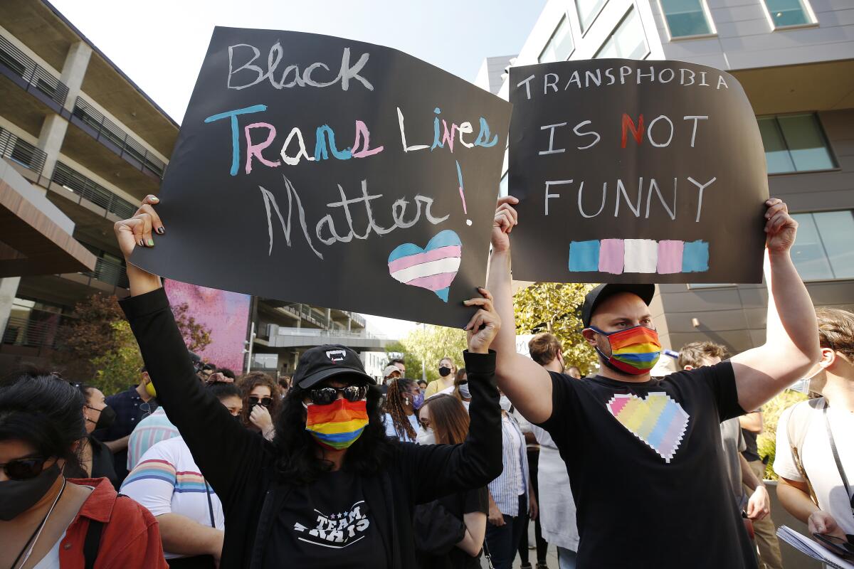 Demonstrators hold up black signs