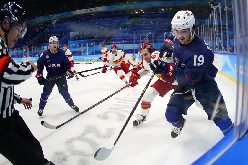 United States' Brendan Brisson (19) battles China's Wei Ruike (Ethan Werek) (61) for the puck.