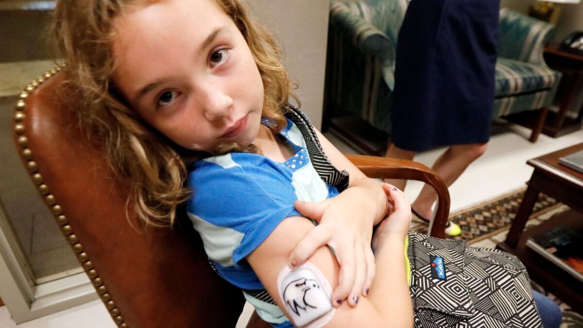 Bella Nichols, 9, shows her insulin patch that Medicaid helps pay for, as her mother meets with U.S. Sen. Thad Cochran's staff in Jackson, Miss. on June 29.