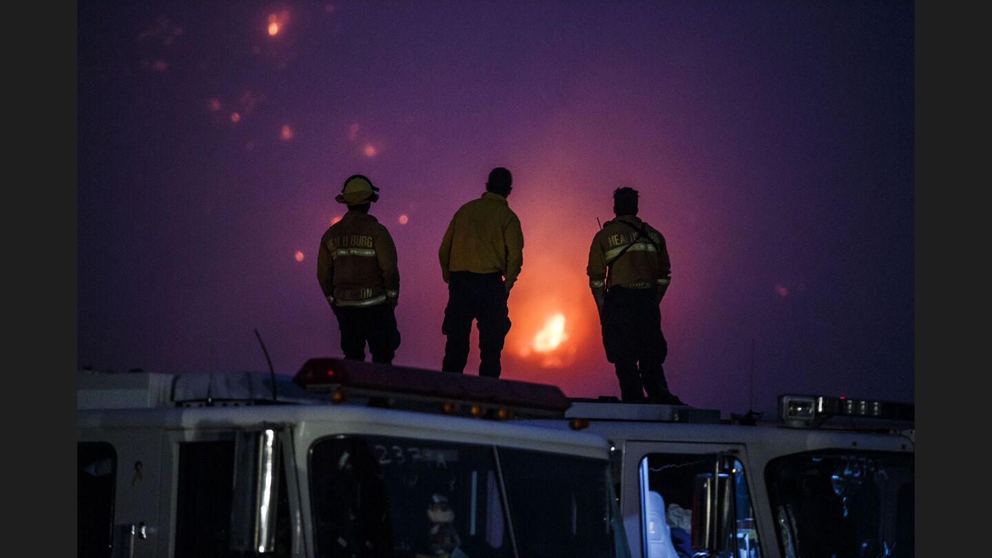 Firefighters monitor the flames Saturday from a staging area near Parma Park in Montecito.