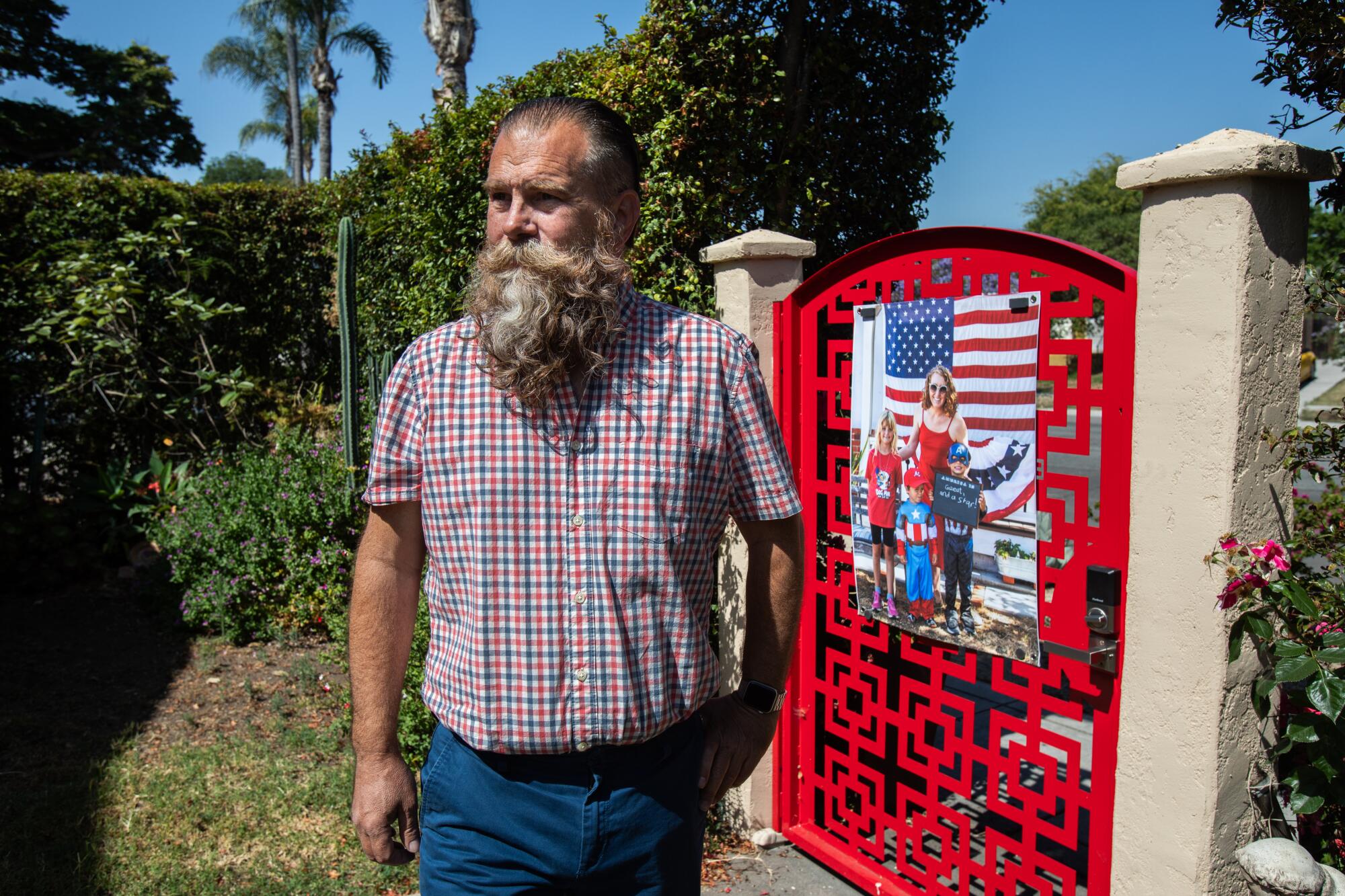 Todd Bradley stands in the front yard of his home next to a portrait he took in Normal Heights