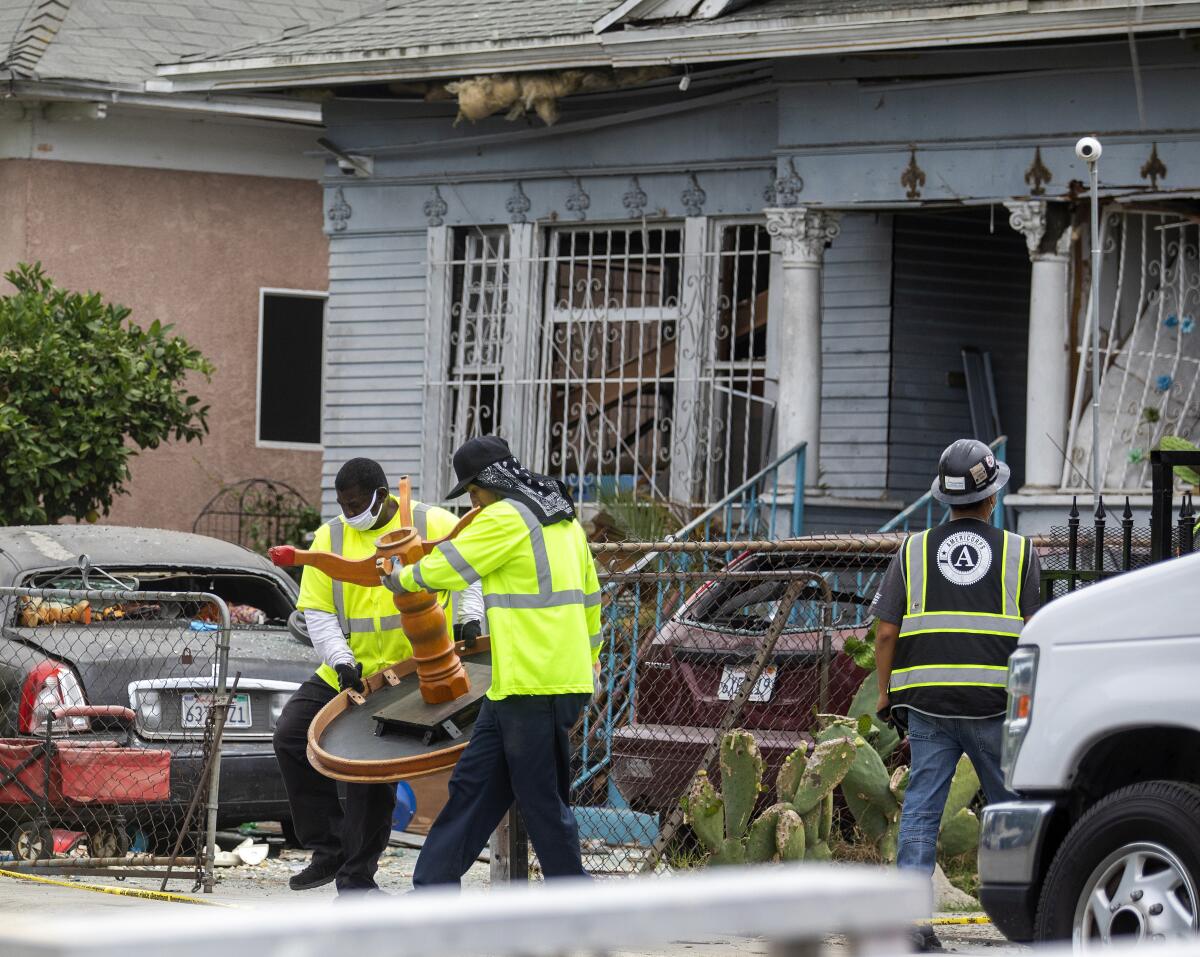 Furniture is removed from a damaged home after the LAPD's disastrous fireworks detonation in South Los Angeles in 2021.