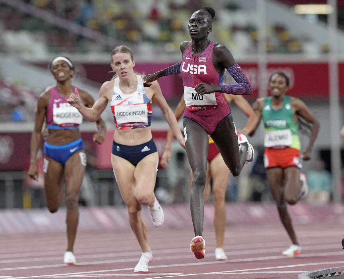 Athing Mu crosses the finish line of the 800 meters at the Tokyo Olympics, ahead of Keely Hodgkinson and Raevyn Rogers