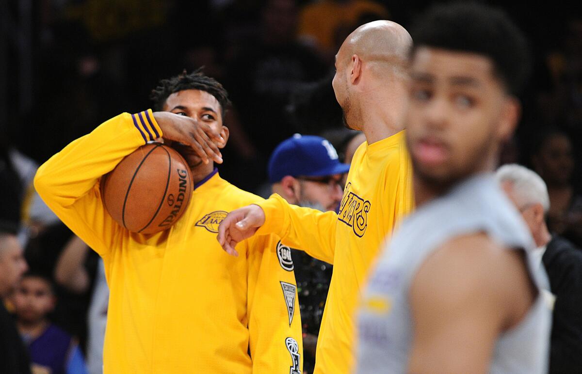 Lakers forward Nick Young, left, and teamate Robert Sacre chat as D'Angelo Russell, right, warms up before a game against the Heat.