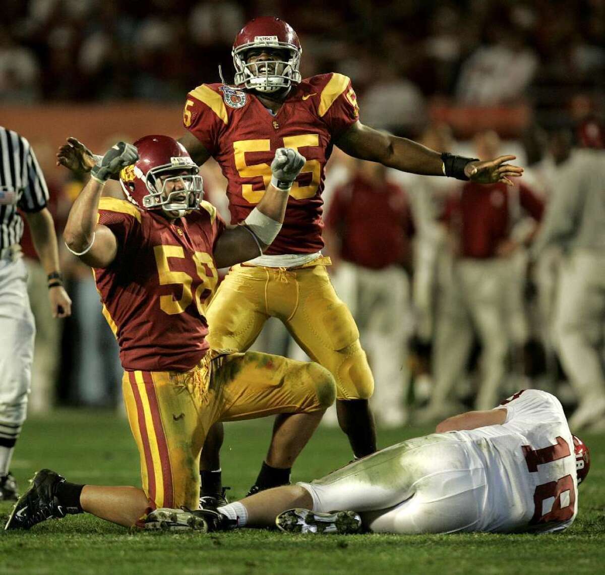 Lofa Tatupu (58) flexes with Keith Rivers (55) after sacking Oklahoma quarterback Jason White in the third quarter in the national championship at the Orange Bowl on Jan. 4, 2005.