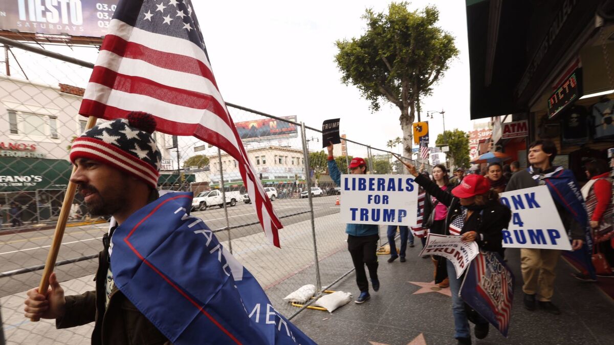 Members of the group San Fernando Valley For Trump Celebration and others march down Hollywood Boulevard in support of the president.