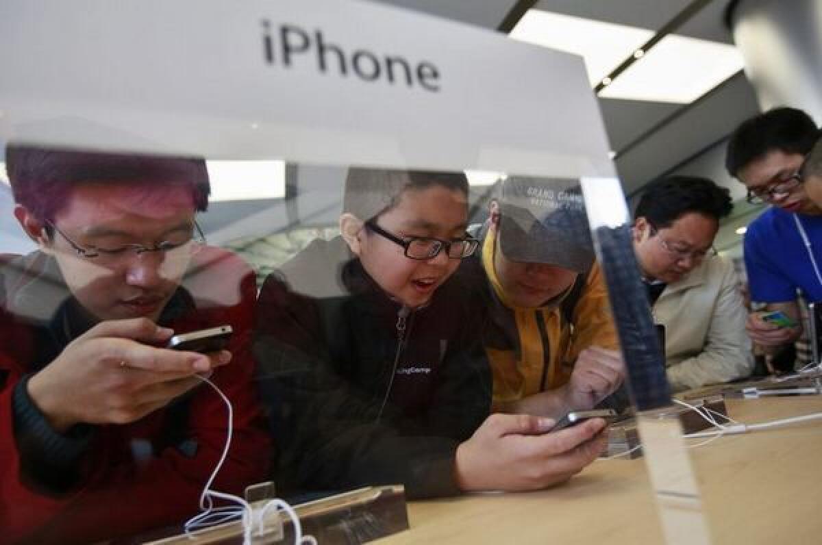 Chinese customers check out the iPhone 4S in the newly opened Apple Store in Wangfujing shopping district in Beijing.