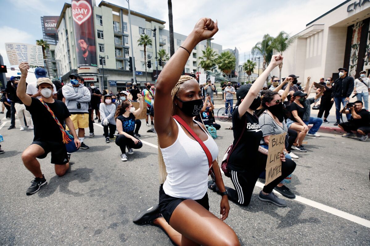 Jessica Jordan takes a knee as she joins other protesters in Hollywood on Tuesday morning.