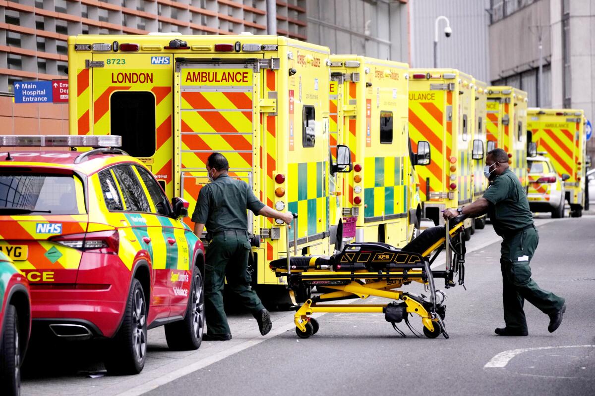 Paramedics push a stretcher next to a line of ambulances outside the Royal London Hospital in East London