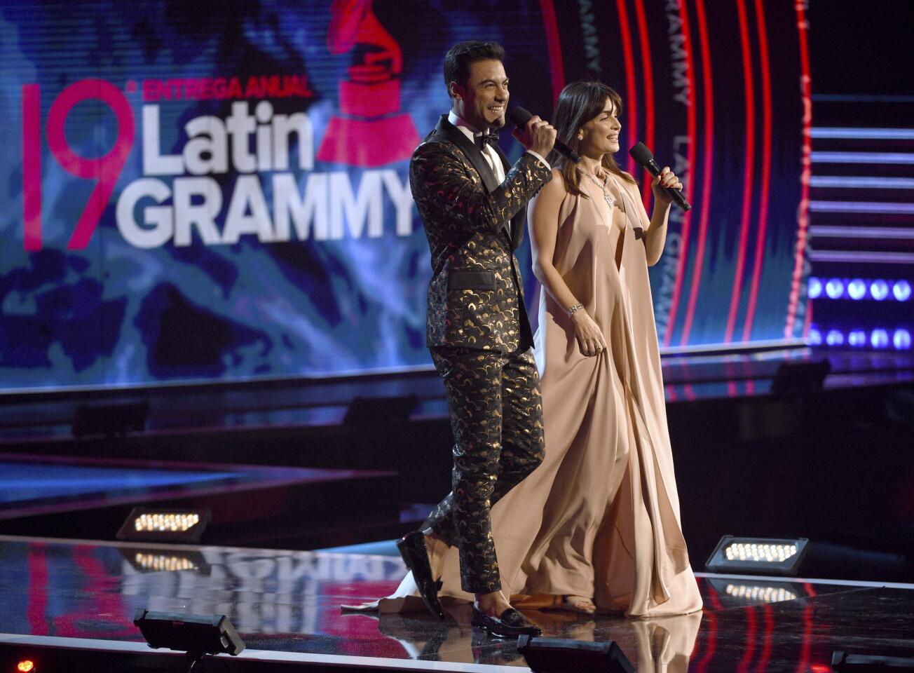 Hosts Carlos Rivera, left, and Ana De La Reguera speak at the Latin Grammy Awards at the MGM Grand Garden Arena in Las Vegas.