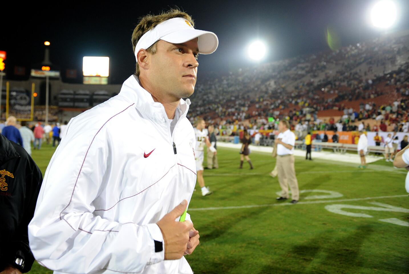 Trojans Coach Lane Kiffin jogs off the field after a 62-51 loss to Oregon on Saturday night at the Coliseum.