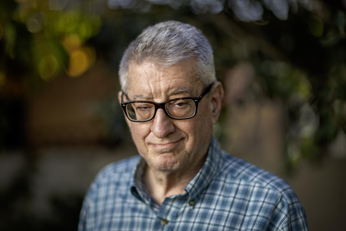 Head and shoulds picture of a gray-haired man wearing glasses