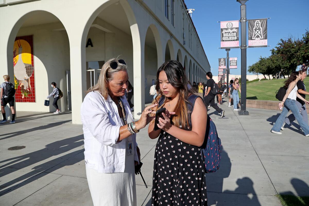 Freshman Kaylee Nguyen, 14, right, asks Huntington Beach High assistant principal Stacy Robison for help Wednesday.