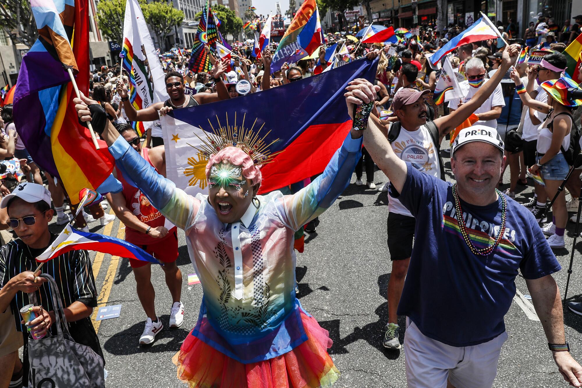 Thousands of people, many with flags, walking along Hollywood Boulevard