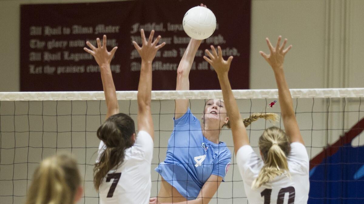 Corona del Mar High's Kendall Kipp, seen putting the ball past two Laguna Beach middle blockers on Sept. 6, 2017, led the Sea Kings to a 25-22, 25-12, 25-22 sweep at Huntington Beach on Tuesday.