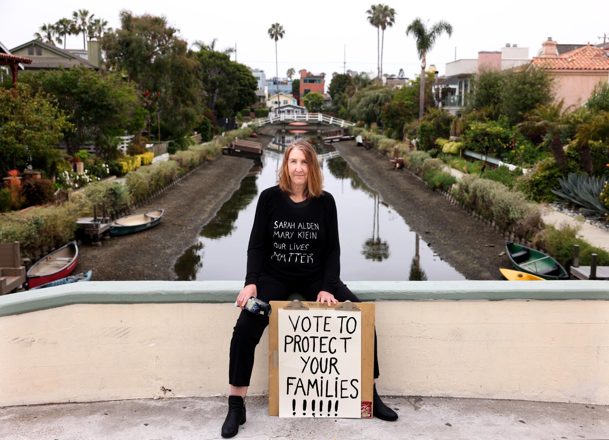 Mary Klein holds a sign reading "Vote to protect your families!"