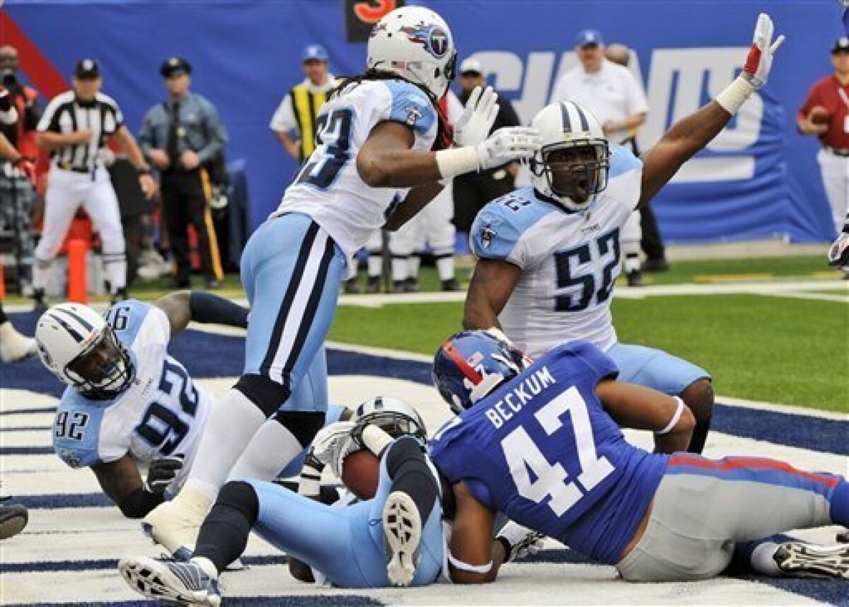 Tennessee Titans Linebacker Jamie Winborn (52) celebrates after teammate Jason McCourty, bottom center, intercepted a pass for a touchback during the first quarter of an NFL football game as New York Giants' Travis Beckum (47) looks on at New Meadowlands Stadium, Sunday, Sept. 26, 2010, in East Rutherford, N.J. (AP Photo/Bill Kostroun)