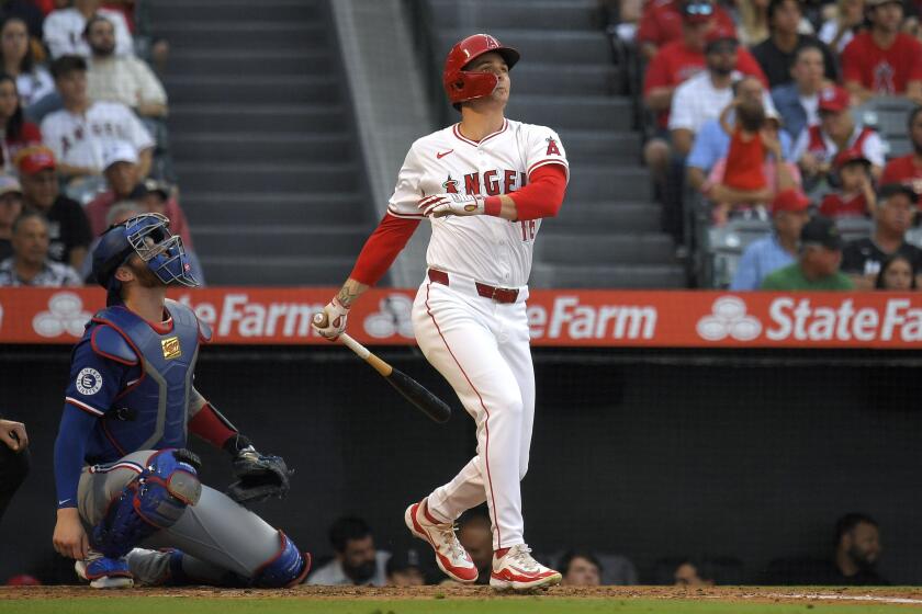 Los Angeles Angels' Mickey Moniak, right, watches his ball go out for a three-run home run as Texas Rangers catcher Jonah Heim watches during the second inning of a baseball game Wednesday, July 10, 2024, in Anaheim, Calif. (AP Photo/Mark J. Terrill)