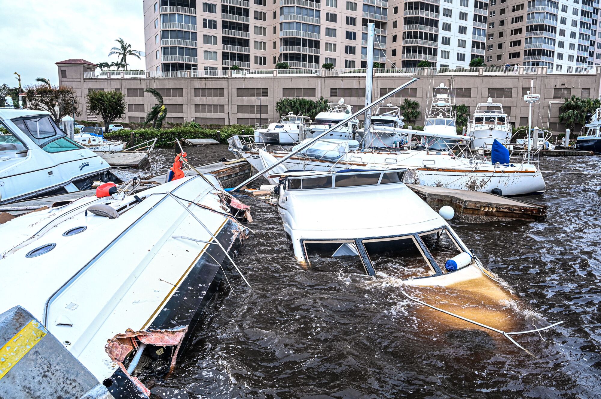 Partly submerged boats in a marina.