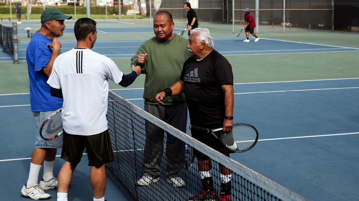 Juan Gonzales, Tommy Bui, Nonie Sibel and Rocky Garcia, from left, fist bump at the end of a tennis match.
