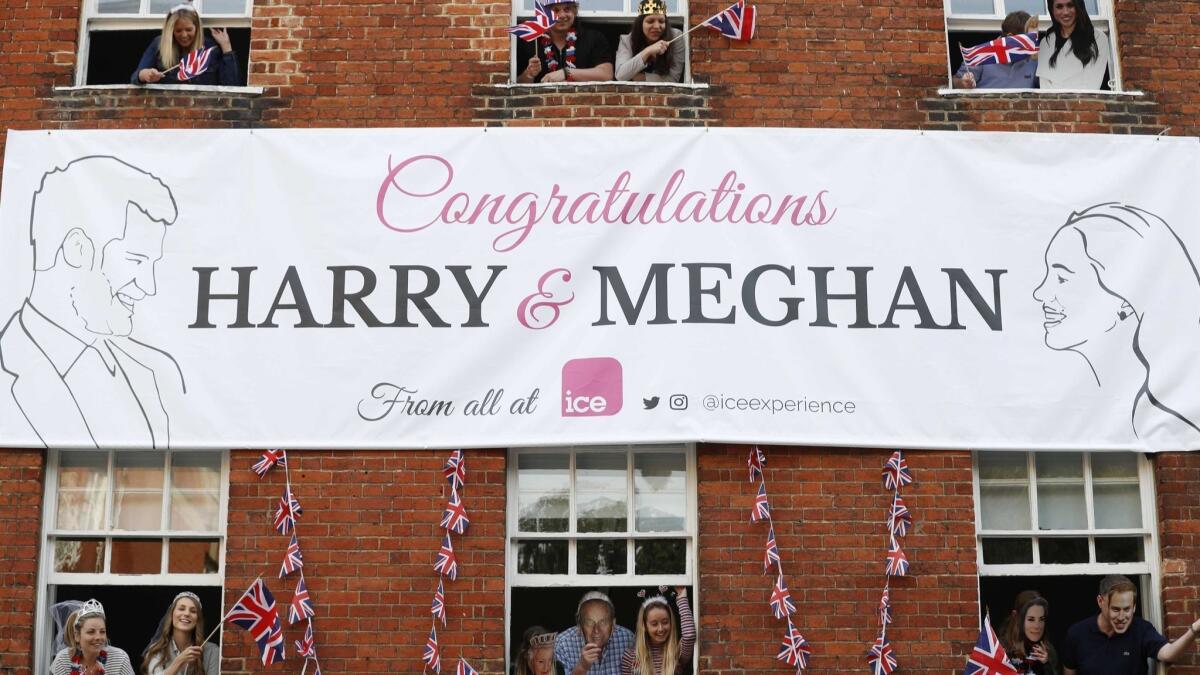 Royal fans lean out of windows as they watch Prince Harry greet well-wishers near Windsor Castle on May 18.