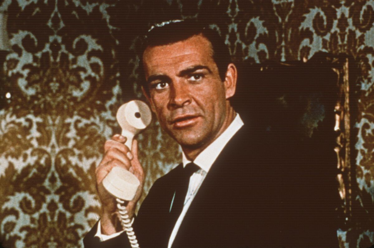 Sean Connery as James Bond holds a white telephone to his ear