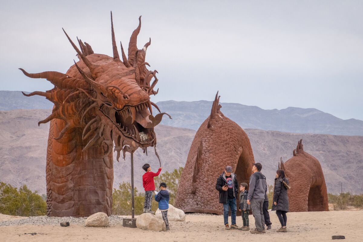 Visitors experience the Borrego Springs Serpent Sculpture up close.