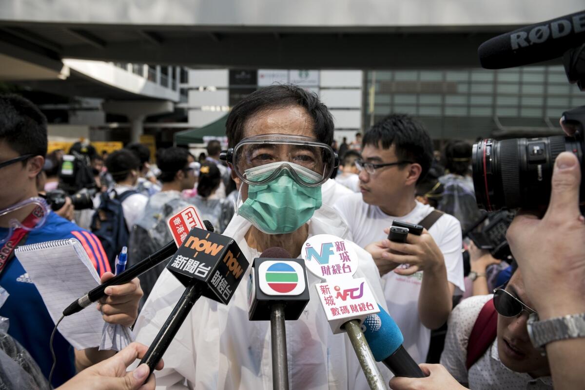 Pro-democracy activist and former legislator Martin Lee, wearing goggles and a mask to protect against pepper spray, talks to the media at a demonstration near the government headquarters in Hong Kong on Sept. 28.
