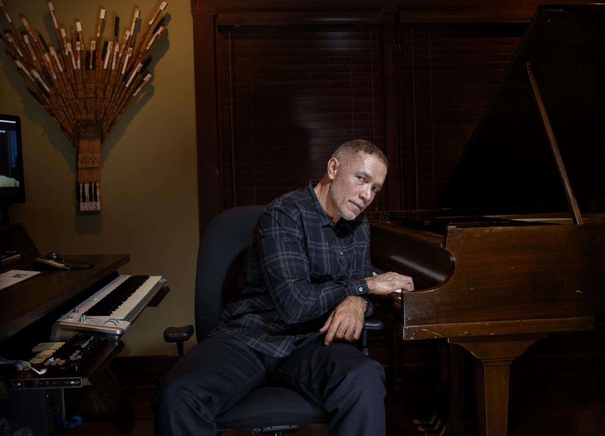 Composer Michael Abels sits at a pair of keyboards.