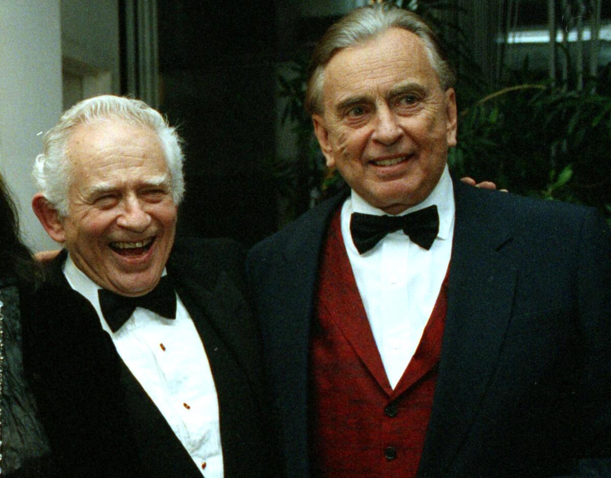 Two men in tuxedos at a party.