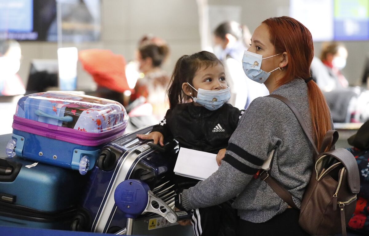 Karen Alvarez and her daughter, Mercedez Gomez, wait in line at the Tom Bradley International Terminal at LAX.