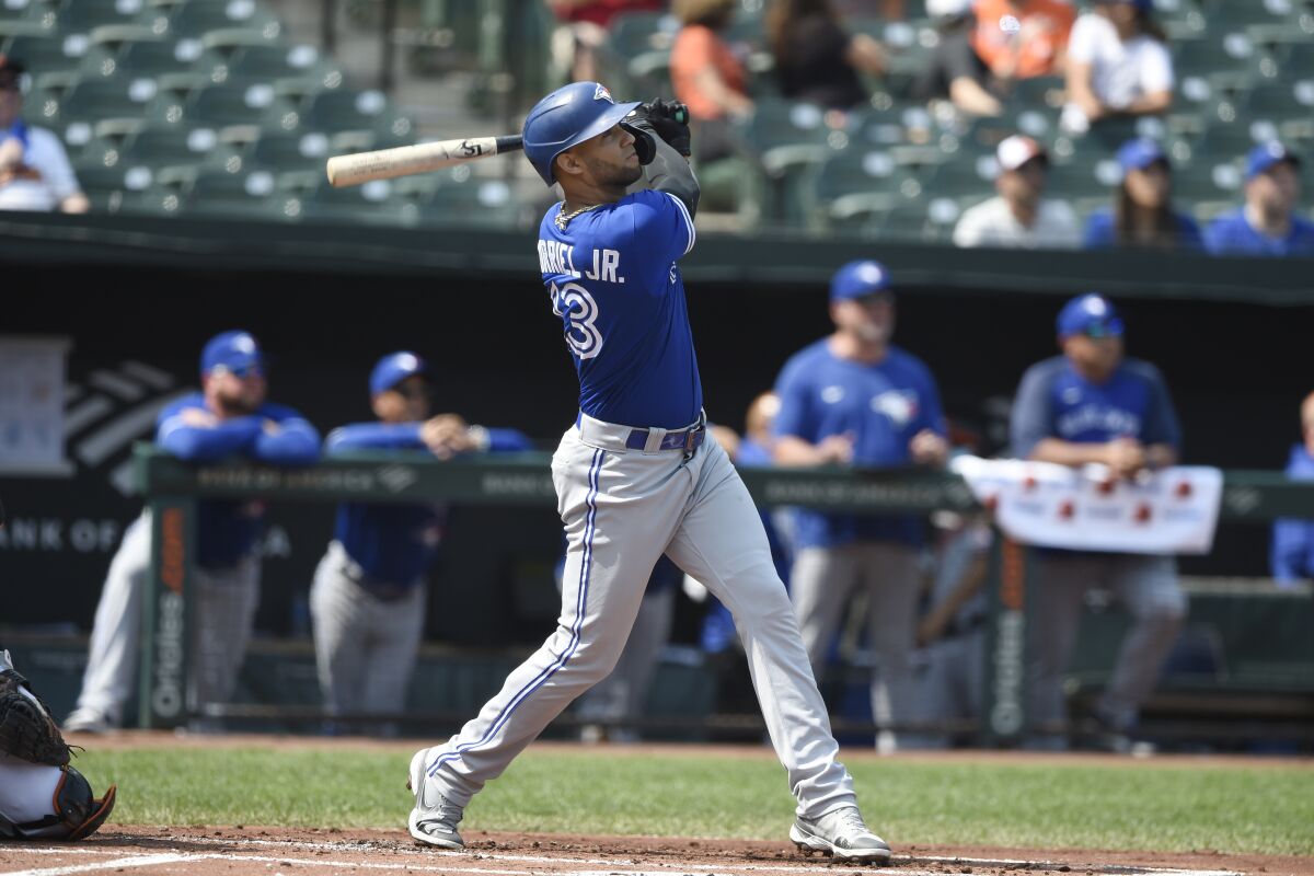 Toronto Blue Jays' Lourdes Gurriel Jr. follows through on a grand slam against the Baltimore Orioles in the first inning of a baseball game Sunday, Sept. 12, 2021, in Baltimore. (AP Photo/Gail Burton)