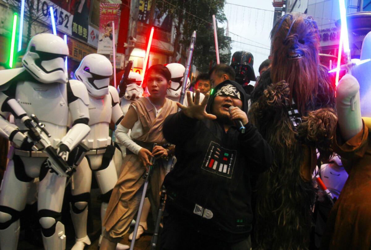 Fanáticos disfrazados de personajes de Star Wars desfilan afuera de un cine que proyecta "Star Wars: El Despertar de la Fuerza" en Taipéi, Taiwán. La película ya superó los 100 millones de dólares en taquilla en Estados Unidos y los 250 millones a nivel mundial, imponiendo un récord para un fin de semana de estreno. (Foto AP/Chiang Ying-ying)