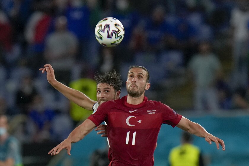 Turkey's Yusuf Yazici, foreground, is challenged by Italy's Manuel Locatelli during the Euro 2020, soccer championship group A match between Italy and Turkey, at the Rome Olympic stadium, Friday, June 11, 2021. (AP Photo/Alessandra Tarantino, Pool)