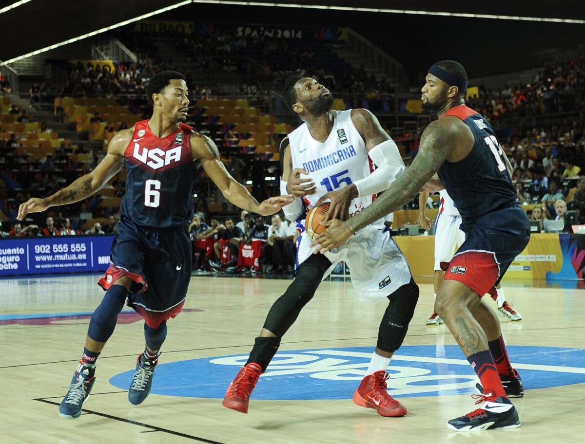 Derrick Rose and DeMarcus Cousins hassle Dominican Republic forward Jack Martinez during a game Wednesday at the FIBA World Cup. USA basketball defeated the Dominican Republic, 106-71.