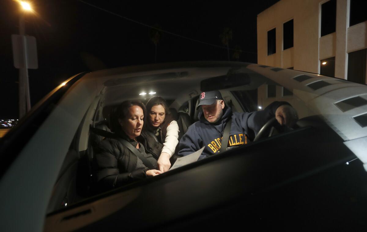 Kathy Creighton, left, and her husband, Ken Creighton, are joined by Kamara Shephard as they figure out directions on a map of San Pedro while performing a count of homeless people from their car.