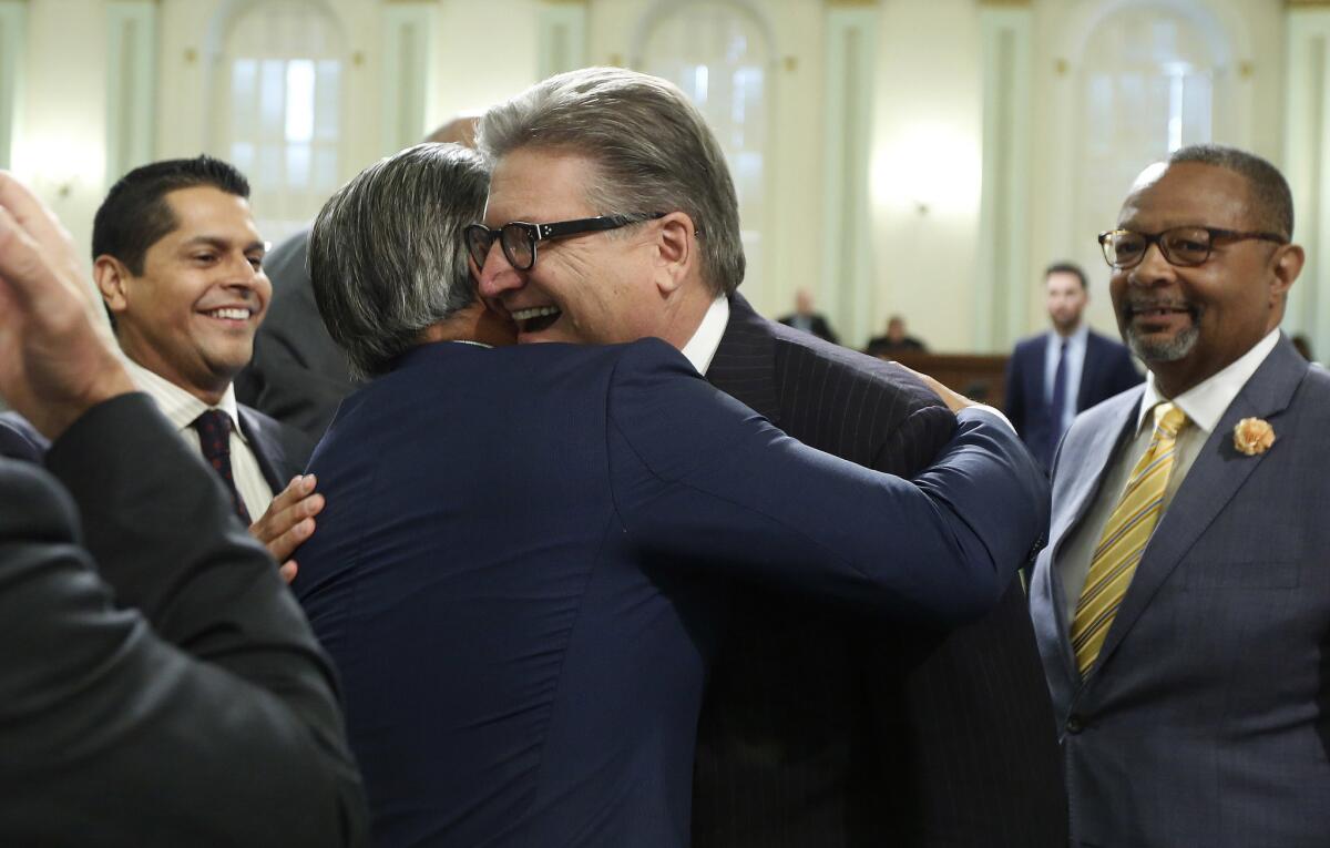 Assemblyman Rob Bonta (D-Alameda), left, and Sen. Bob Hertzberg (D-Van Nuys) celebrate after the bail overhaul was approved by the Assembly.