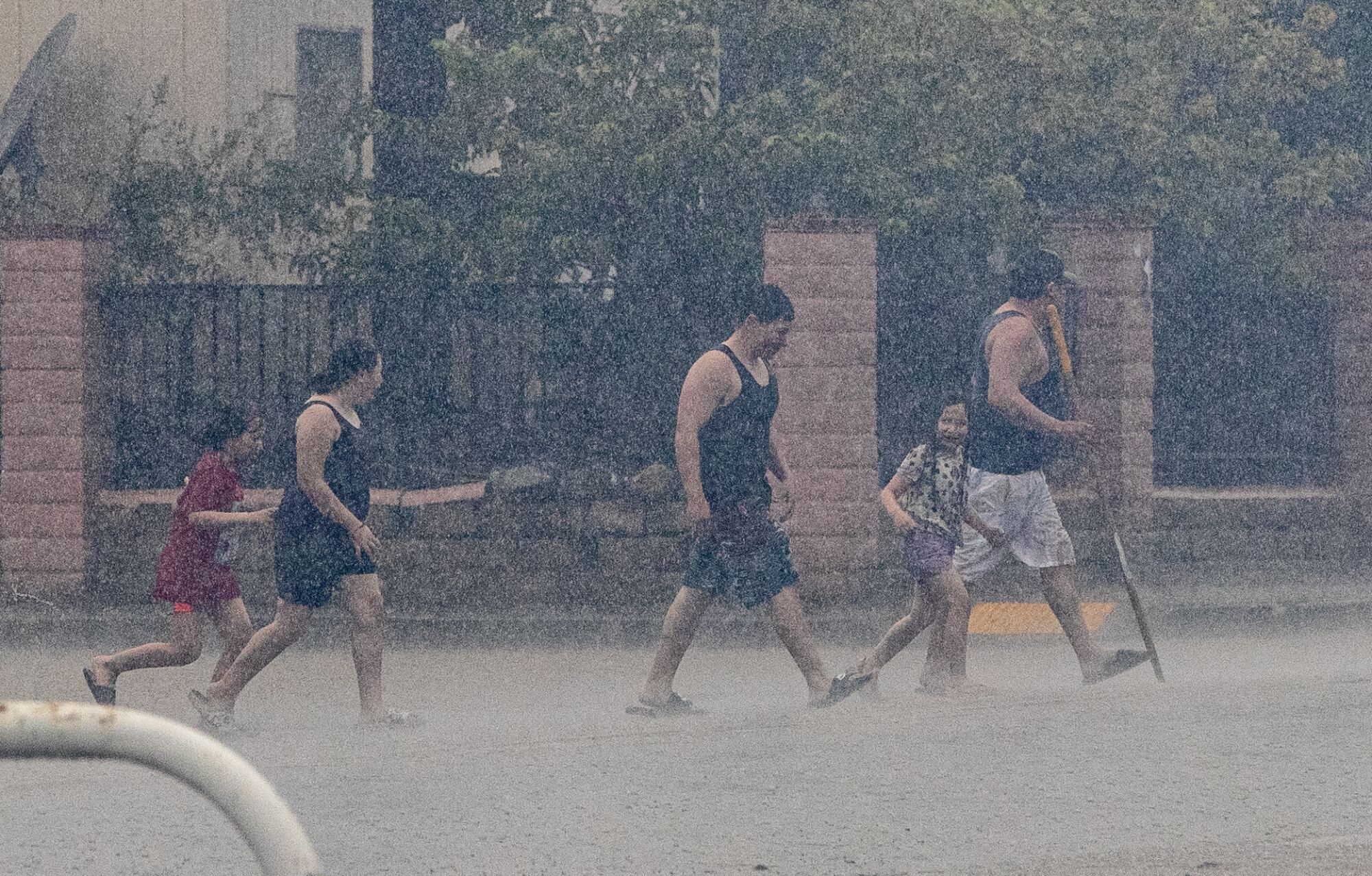 People walk across a street in the rain 