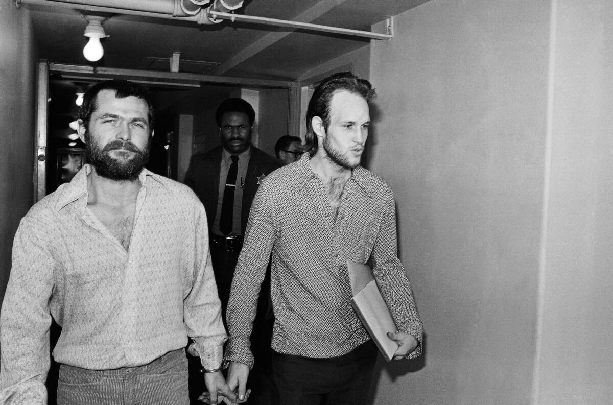 This Dec. 22, 1970, photo shows Charles Manson followers Bruce Davis, left, and Steve Grogan leaving court after a hearing in Los Angeles.
