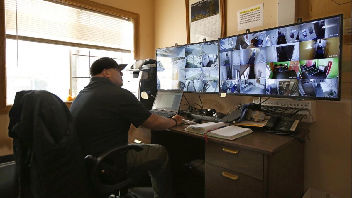 California Correctional Officer Alejandro Martinez monitors surveillance cameras at the Male Community Re-entry Program, an alternative custody unit in Oroville, Calif.