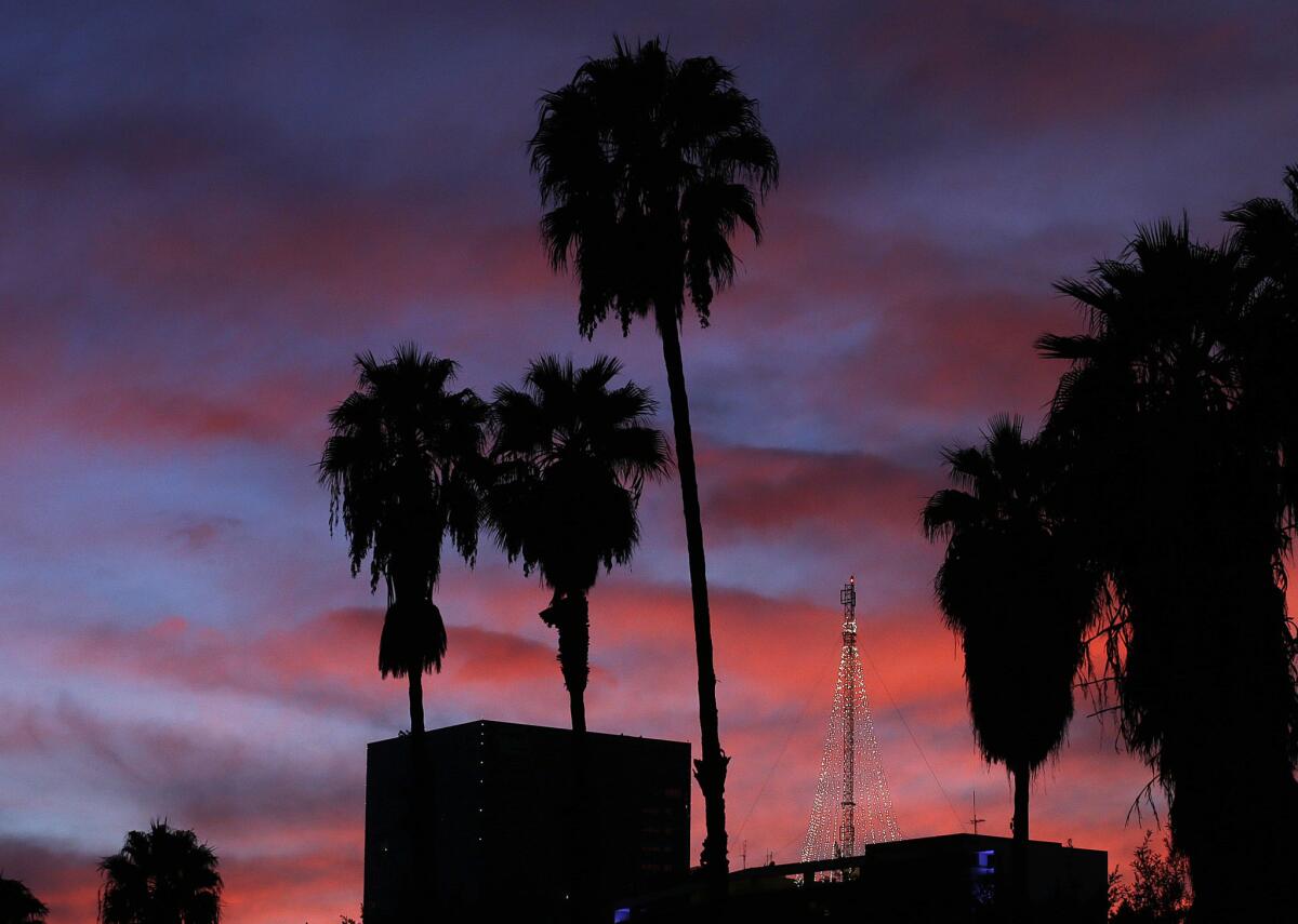 The sun sets over downtown Los Angeles on Monday. A cold air mass is expected to push down temperatures beginning Tuesday.