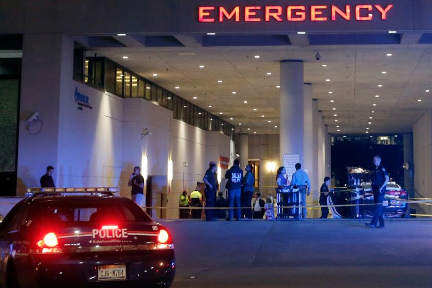 Law enforcement officers stand outside the emergency room at Baylor University Medical Center, early July 8.