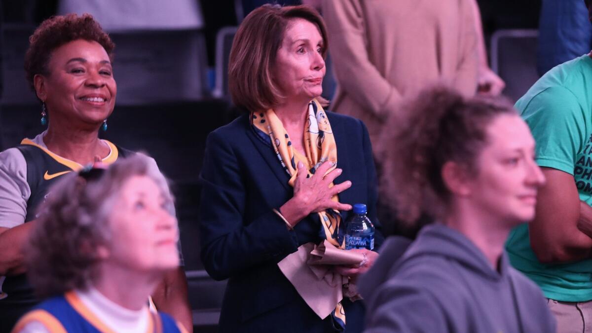 Rep. Barbara Lee, left, and House Speaker Nancy Pelosi stand for the national anthem before the start of the Washington Wizards-Golden State Warriors game at Capital One Arena on Jan. 24. Both represent congressional districts in the Bay Area.
